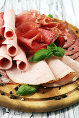 Food tray with delicious salami, pieces of sliced ham, sausages,salad and vegetable. Meat platter with selection