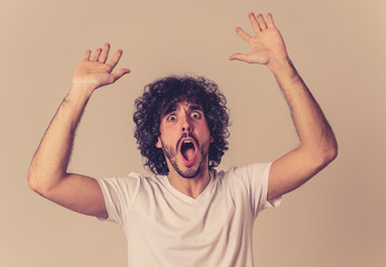 Happy young attractive man shocked with a surprised funny face. Human expressions and emotions.