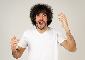 Happy young attractive man shocked with a surprised funny face. Human expressions and emotions.