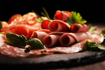 Food tray with delicious salami, pieces of sliced ham, sausages,salad and vegetable. Meat platter...