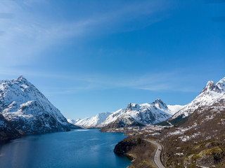 Obraz na płótnie Canvas Road along fjord and mountain with snow cap in Norway