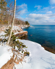 Beautiful trees and Lake Superior coastline in the cold and snow at Big Bay State Park - Madeline Island in Northern Wisconsin - sunny day with blue skies