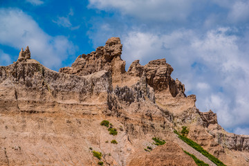 Fototapeta premium Badlands National Park - Landscape of eroded rock formations, clouds, and blue sky