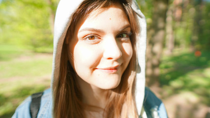Naklejka premium Calm beautiful smiling young woman enjoying fresh air , relaxing , feeling alive, breathing, dreaming. Copy space, green park nature background. Side view portrait