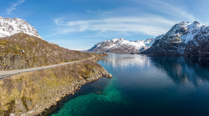 Road along fjord and mountain with snow cap in Norway
