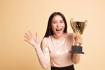 Successful young asian woman holding a trophy.