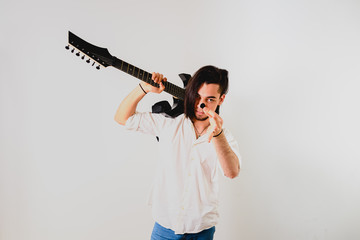 Guitarist posing with his electric guitar, white background.