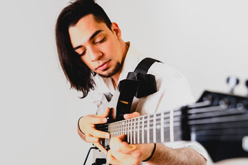 Guitarist posing with his electric guitar, white background.