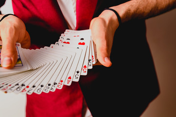 Hands of magician doing tricks with a deck of cards.