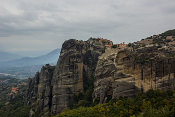 heritage orthodox religion highland monastery holy place for traveling and pilgrimage in beautiful scenic outdoor place with picturesque rocks in Greece in dramatic cloudy and rainy weather 