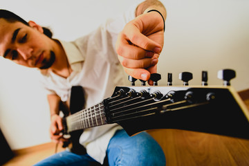 Guitarist posing with his electric guitar, white background.