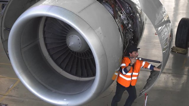Maintenance of aircraft. Repair of the tail of the aircraft. The engineer repairing the aircraft.. 4k.