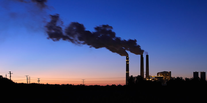 Smoke emitting from factory smoke stacks at night