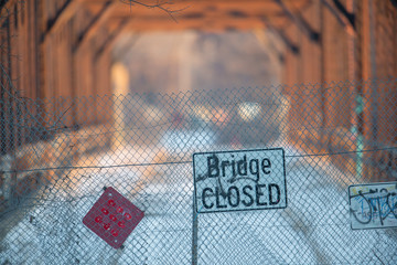 Bridge closed sign in front of dilapidated bridge