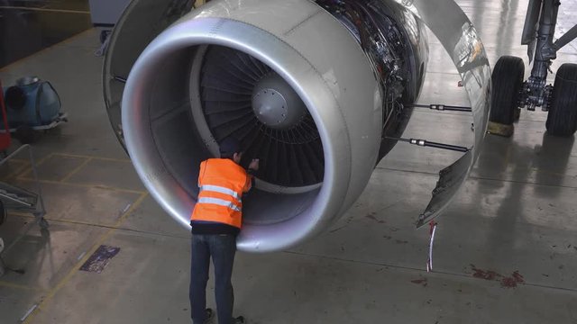 Maintenance of aircraft. Repair of the tail of the aircraft. The engineer repairing the aircraft.. 4k.