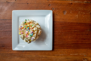 beautiful single cupcake with sprinkles on plate