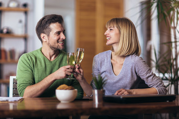 Couple talking in the night in the living room at home and drink wine.
