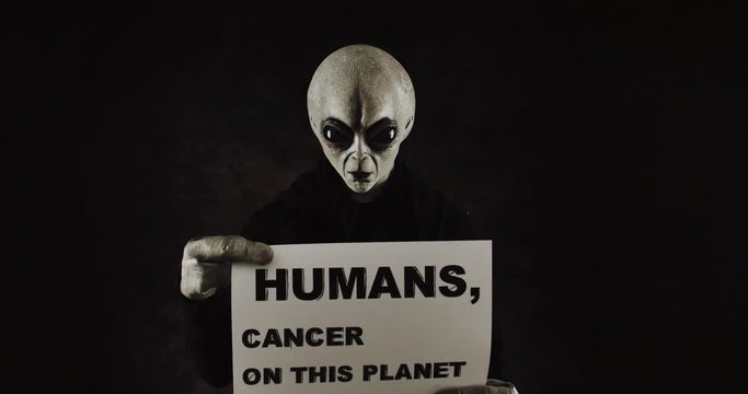 Grey alien creature has messages for human. posing in front of the camera