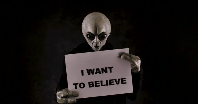 Grey alien creature has messages for human. posing in front of the camera