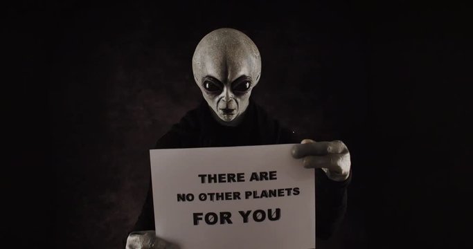 Grey alien creature has messages for human. posing in front of the camera