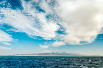 Fototapeta premium Seascape, view of the blue sea with high bald mountains in the background