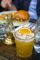 old-fashion whiskey at a restaurant with food in the background