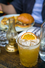 old-fashion whiskey at a restaurant with food in the background