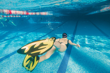 woman in yellow flippers swimming in pool