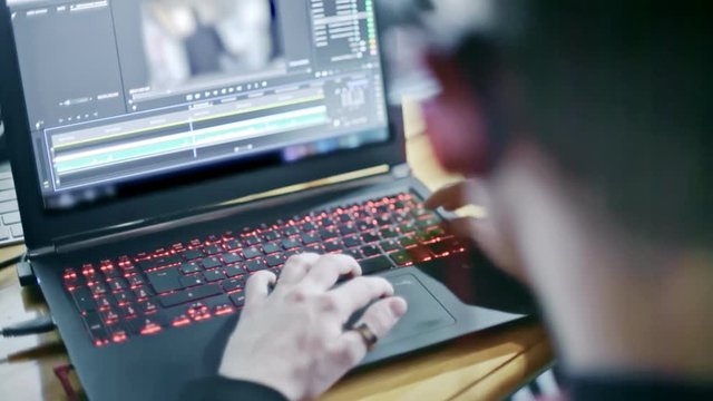 Professional video editor working on a laptop