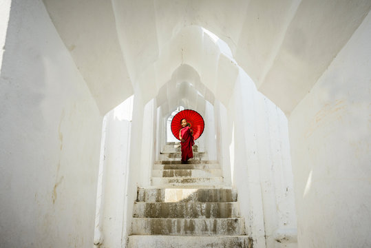 Asian monk under umbrella on temple staircase, Mingun, Mandala, Myanmar