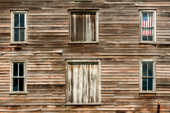 Wooden house exterior with American flag in window