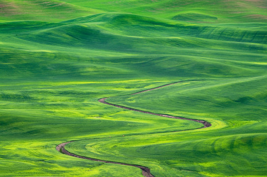 Winding irrigation ditch through rolling hills in rural landscape
