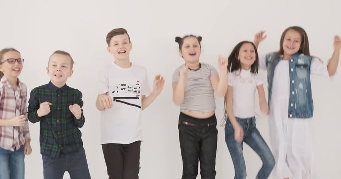 Excited boys and girls jumping in studio