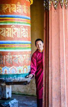 Asian monks standing by pillar in temple