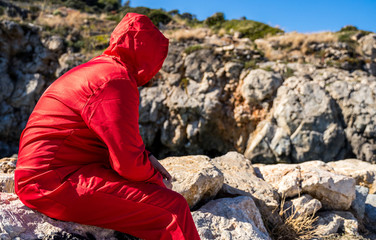 MAIN CHARACTER APPEARS WITH THE RED SUIT ON THE BEACH OF THE PHILIPPINES, THINKING ABOUT THE FORM OF LEAVING