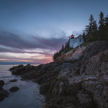 House on cliff near ocean at sunset
