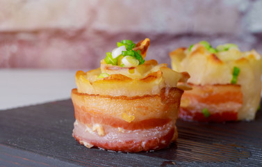 Yellow sliced potatoes with bacon cooked in the oven