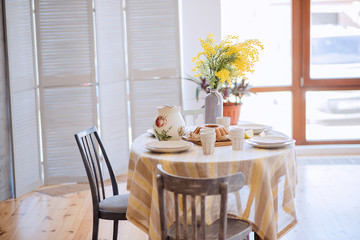 Dining table in the living room. Beautiful table setting. Stylish and trendy decor.