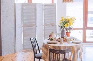 Dining table in the living room. Beautiful table setting. Stylish and trendy decor.