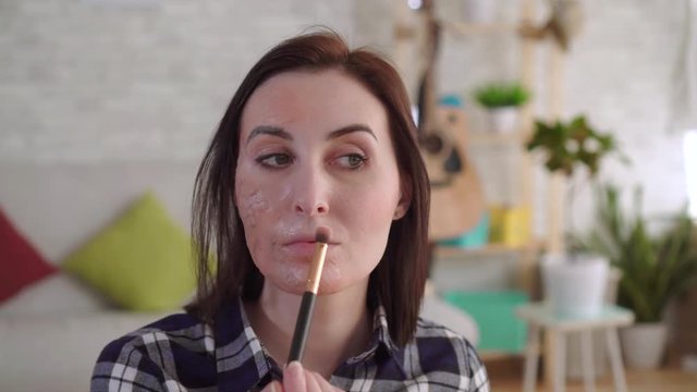 Young woman hides a scar on her face with makeup