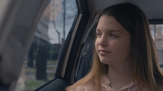 CU of a teen girl driving in the car and looking through the window