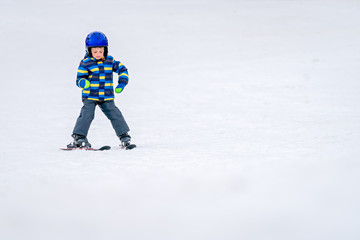 Fototapeta na wymiar Little boy skiing for the first time
