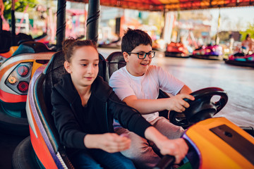 Friends in amusement park driving bumper car