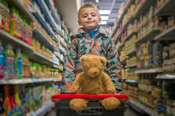 Boy on a shopping errand with his teddy bear