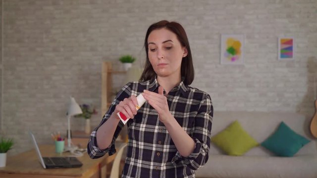young woman puts cream on a scar from a burn on her face