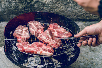 Close up on red pork pig meat cooking on the barbeque outdoor grill food