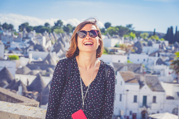 happy tourist take selfie photo in Alberobello town, Apulia, southern Italy. The town of...