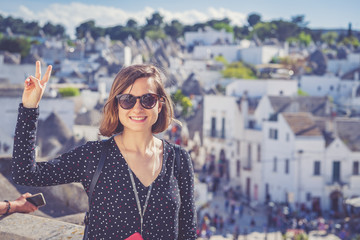 happy tourist take selfie photo in Alberobello town, Apulia, southern Italy. The town of alberobello is famous for the typical trulli houses