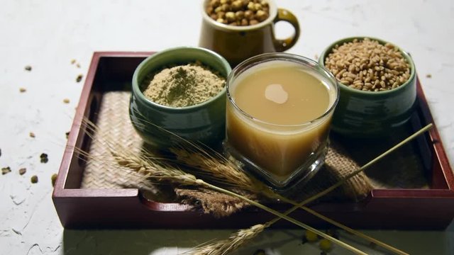 Sattu sharbat is a cooling sweet drink made in summer with roasted black chickpea flour, barley, suger, salt & water. served in a glass. selective focus