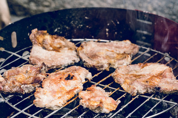 Close up on pork meat cooking on the barbeque outdoor grill food